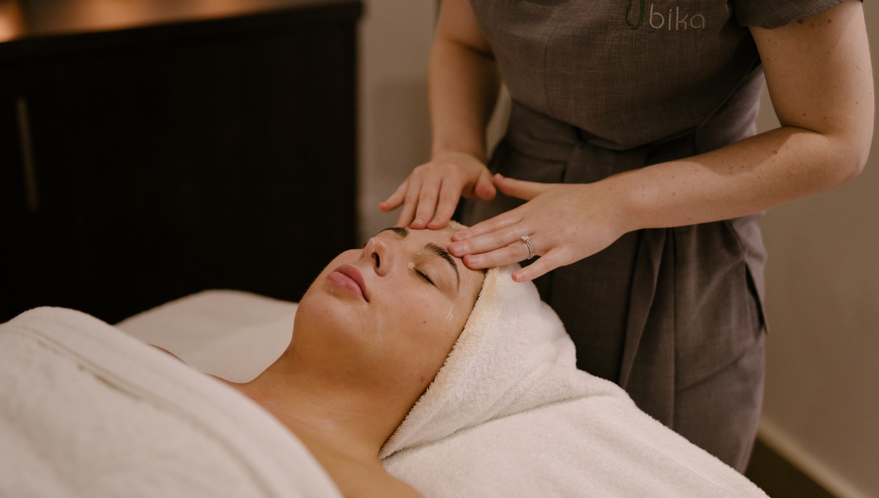 Photograph of a woman enjoying a rejuvenating facial treatment in our serene day spa.