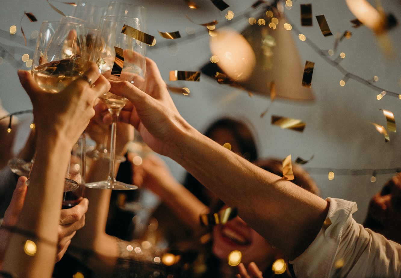 Guests raising glasses in a festive Christmas celebration.